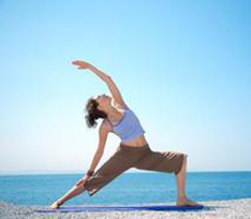 woman doing hatha yoga pose on sea beach