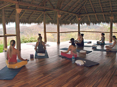 women practicing yoga at wooden yoga deck
