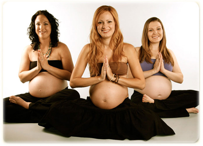 three pregnant women practicing yoga